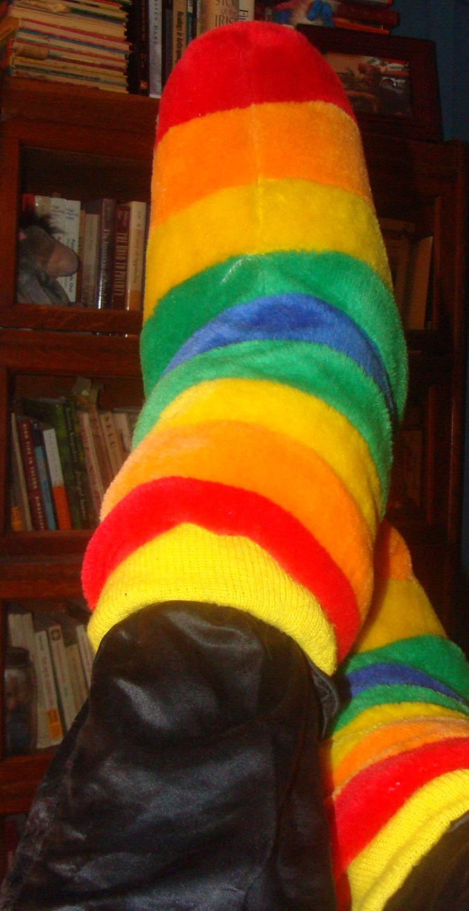 Connie has stuffed the legs of her elegant Kate Hepburn black silk pajamas into the tops of her big fuzzy house shoes.